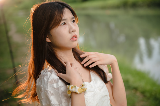 Beautiful asian girl by the river at dusk