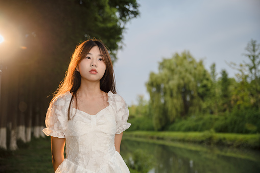 Beautiful asian girl by the river at dusk