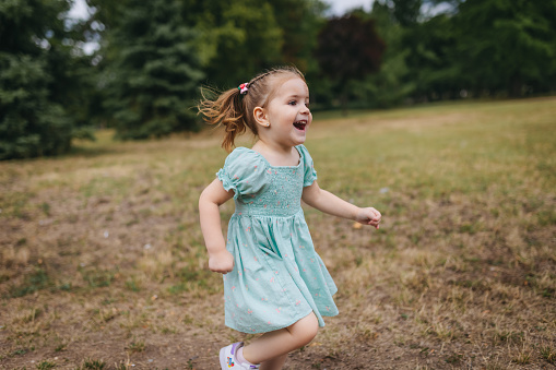 Happy little girl running in the nature