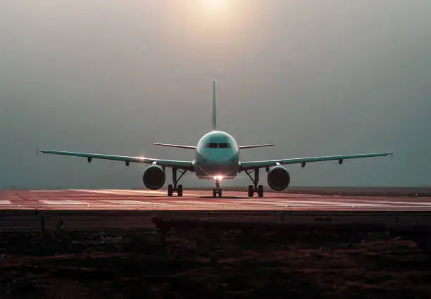 Photo of commercial airplane preparing for takeoff on the runway, front view
