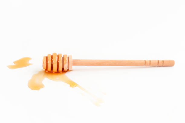Honey dipper and honey drop on white background