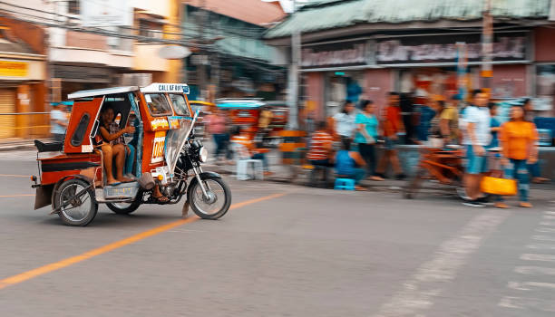 A Motor Cab in Tacloban City One of the basic public transportation in City of Tacloban is what they call "Tricycle". A motor-cab for hire, it's like a taxi with a minimum fee. It can accommodate 2-3 persons at a time. philippines tricycle stock pictures, royalty-free photos & images