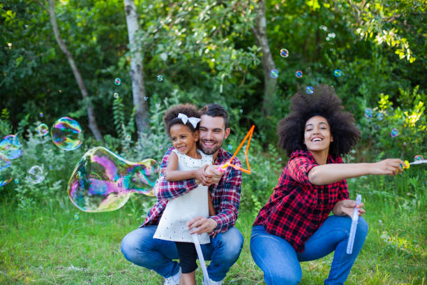 istock Happy family playing soap bubbles in park 1409792734