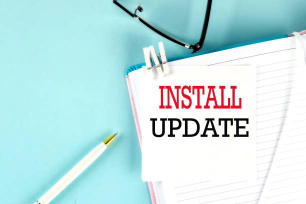 istock INSTALL UPDATE text on a sticky on notebook with pen and glasses , blue background 1409792767