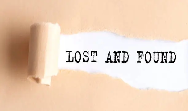 Photo of The text LOST AND FOUND appears on torn paper on white background.