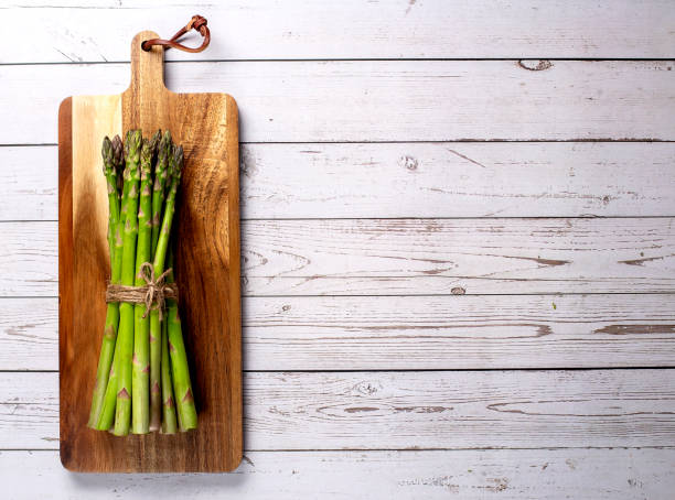 istock Green asparagus on wooden board . Top view flat lay. Copy space 1409792782