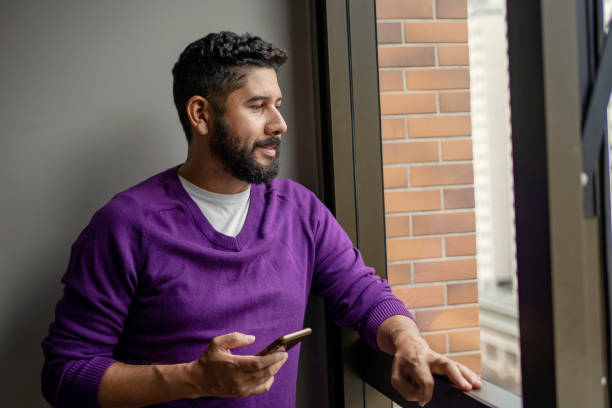 istock Latin young man using smart phone at home 1409795812