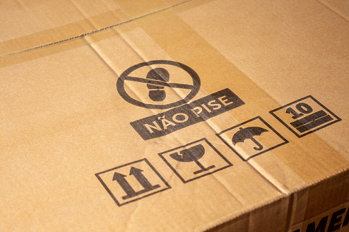 Closeup on a Cardboard Box with Caution Symbols. Product and courier delivery concept.