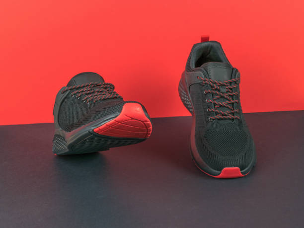 istock Black and red sneakers imitating walking on a black and red background. 1409799031