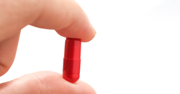 istock Holding a red antianxiety capsule with a white background and copy space 1409799591