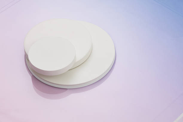 istock Thre circular white risers on gradient pnk to blue background. Mock up background for product placement. 1409800843