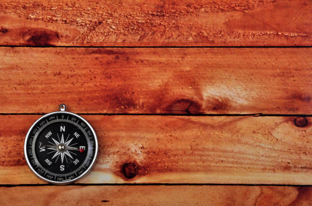 A compass over a wooden plank boarwalk.
