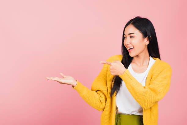 istock woman smiling standing pointing finger out 1409803797