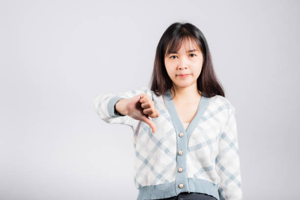 Unhappy woman smile show finger thumbs down rejection unlike stock photo