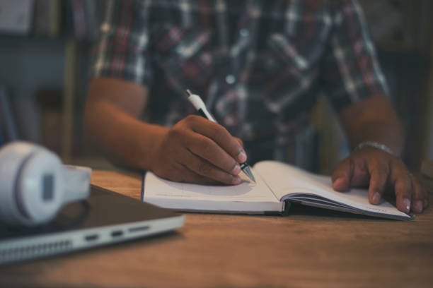 istock Businesman planning daily appointment and note holiday trip schedule in diary at office desk. Planner write meeting agenda on 2023 Calendar, work online at home. Calendar reminder event concept. 1409808436