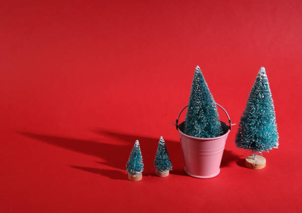istock Minimal christmas concept. Christmas trees with a bucket on a bright red background 1409808503