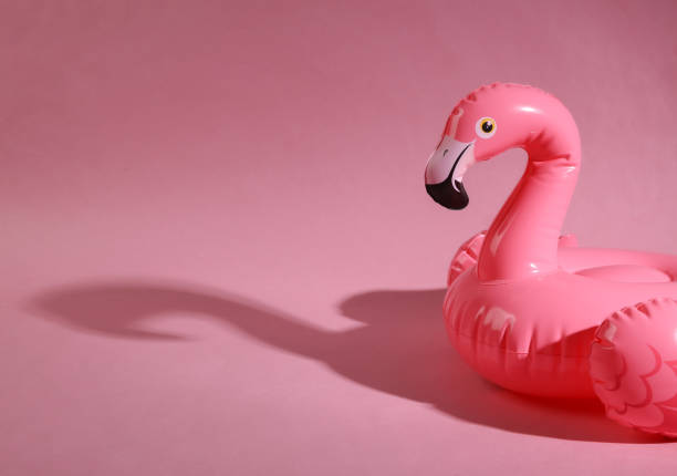 istock Pink inflatable flamingo with shadow on a pink background. Minimal summer layout 1409808527