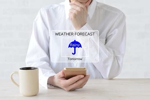 Woman checking weather forecast with smartphone