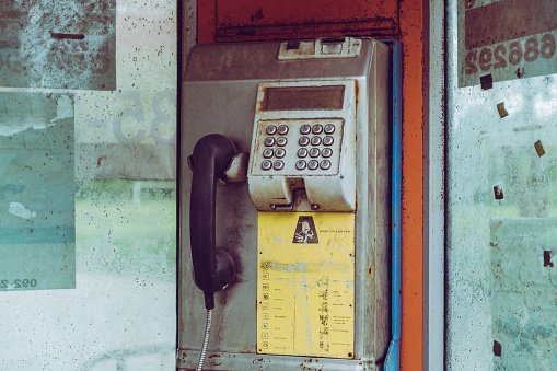 Old public damaged pay phone in rural at Thailand.