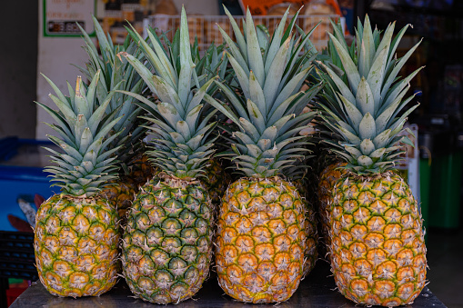 Amount of fresh ripe pineapple fruit for sell in a traditional market in Taiwan. \nTasted and fresh pineapple as a background. Summer fruit.