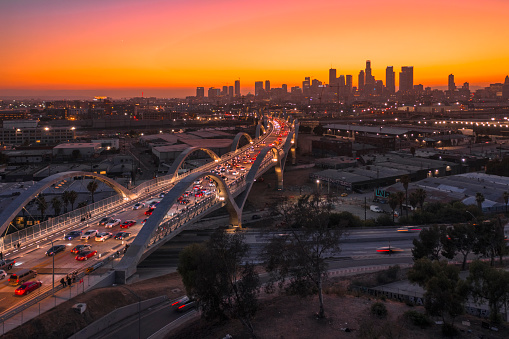 The new 6th Street Bridge viaduct with the Los Angeles downtown city skyline during a beautiful sunset