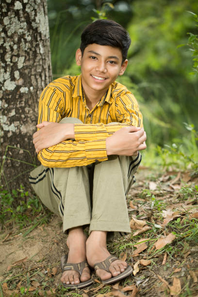 istock Happy rural boy sitting in nature 1409820160