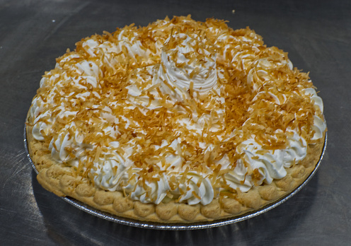 Coconut cream pie toped with whipped cream and toasted coconut.