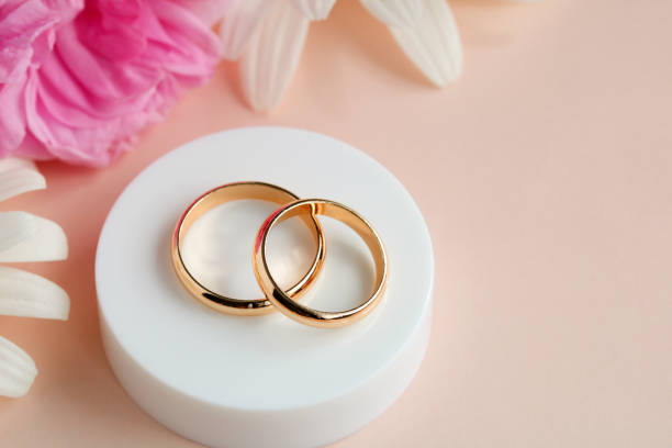 istock Two gold rings on pink. Festive wedding background. 1409821186