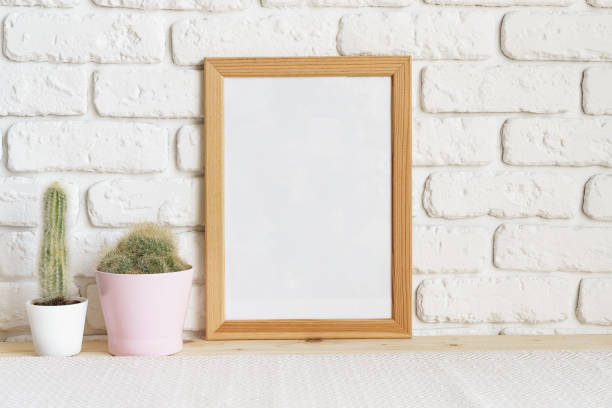 istock Square wooden photo frame and cactus plants on the table 1409822179