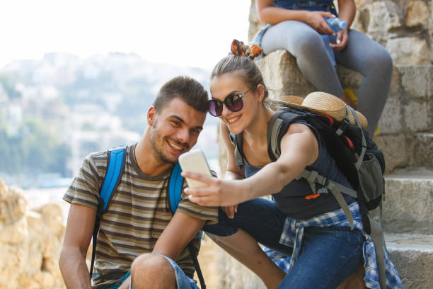 istock Couple taking selfies with smart phone while taking a break from hiking 1409822499
