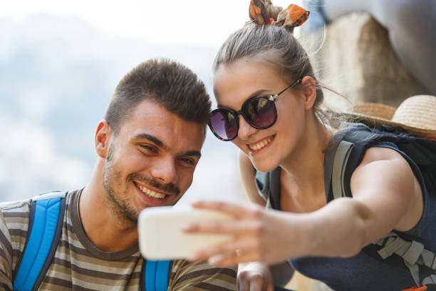 istock Smiling couple taking selfies while taking a break from the hike 1409822513