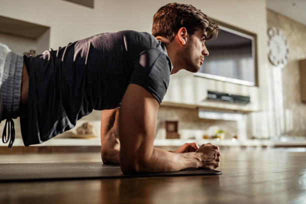 istock Muscular build man exercising endurance in plank position. 1409823490