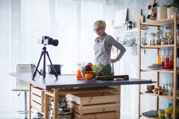 istock Senior food vlogger putting on her apron when preparing to film a video 1409823607