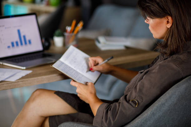 istock Businesswoman working on a project, writing notes in a notepad 1409824585