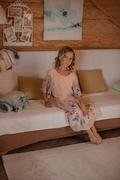 istock A girl in a dress poses on a sofa. 1409824913