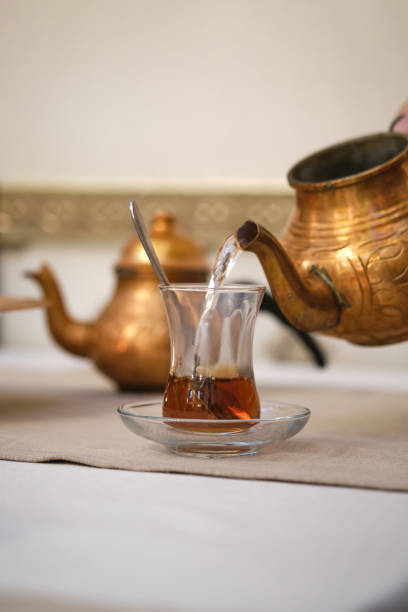 istock A man's hand pours tea into a Turkish cup from a copper teapot. 1409827377