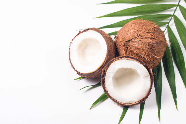istock Ripe half cut coconut with green leaves on a white background. Isolated concept. 1409828190