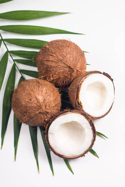 istock Ripe half cut coconut with green leaves on a white background. Isolated concept. 1409828192