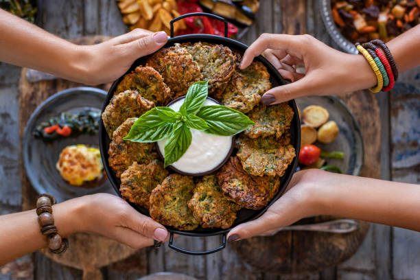 molti flitter di verdure nel piatto con salsa bianca. mücver o mucver. - latke foto e immagini stock