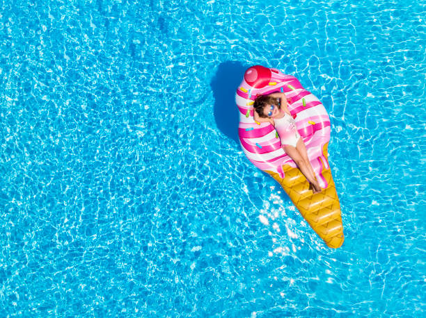 ein blondes mädchen genießt einen heißen sommertag auf einem eisförmigen wagen - badeanzug stock-fotos und bilder