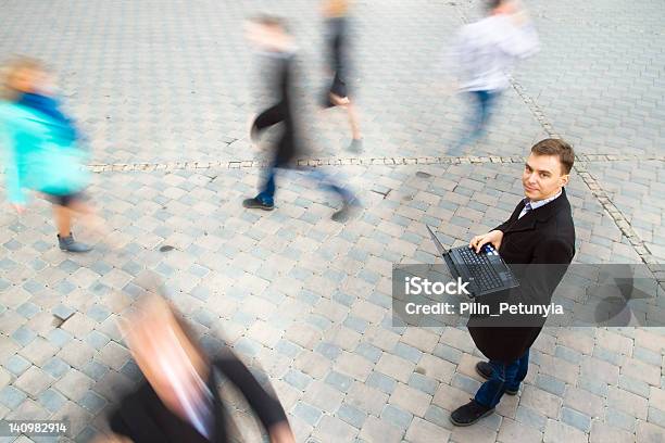 A Businessman Walking While Carrying His Laptop Stock Photo - Download Image Now - Abstract, Adult, Adults Only