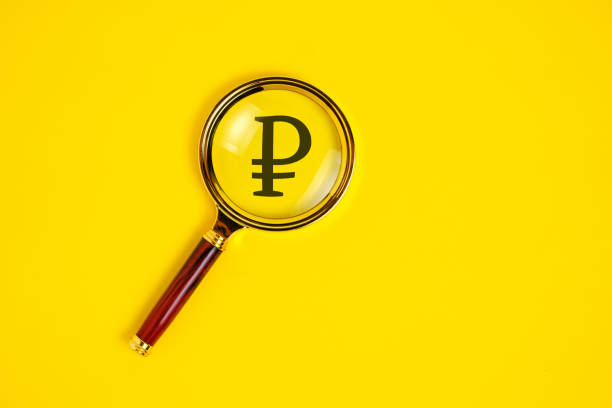 istock Ruble symbol under magnifying glass, on yellow background. 1409829537