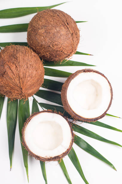 istock Ripe half cut coconut with green leaves on a white background. Isolated concept. 1409830845