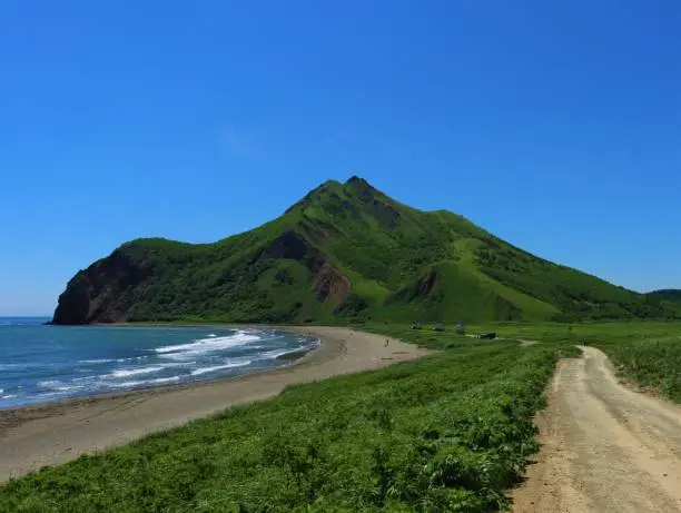 View of the mountain and the coast in Tikhaya Bukhta, located on the east coast of Sakhalin Island, Russia. Bright and picturesque scenery.