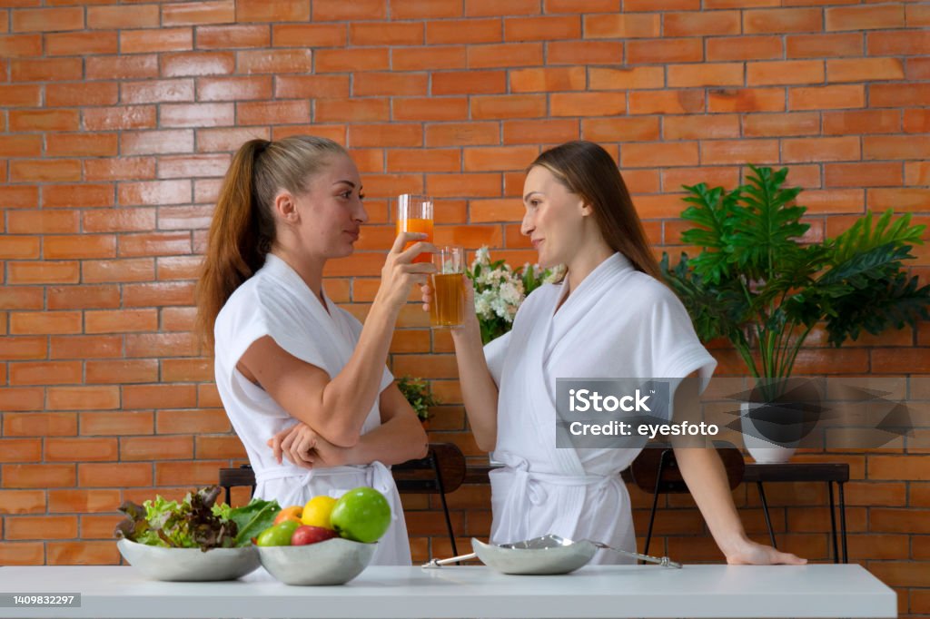 Two women making healthy food at home. They are live streaming. Two women making healthy food at home. They are live streaming. Beauty and healthy concept. 25-29 Years Stock Photo