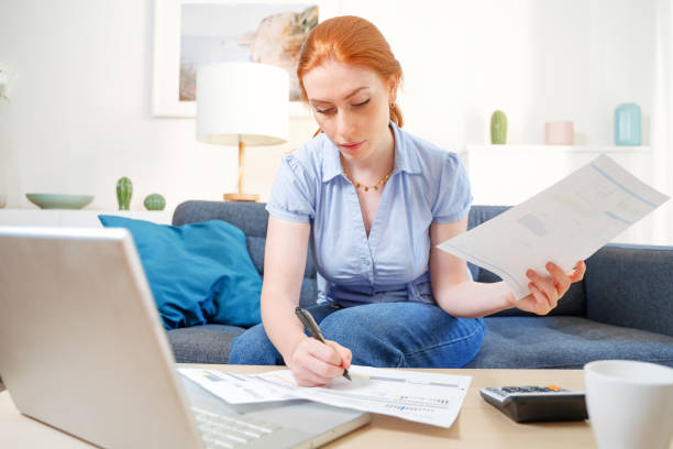 istock Woman analyzing financial budget with calculator at home 1409833790