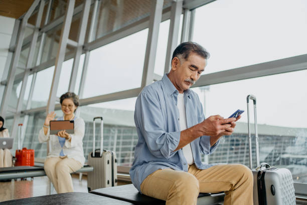 istock Senior Asian man using smartphone in airport 1409835220
