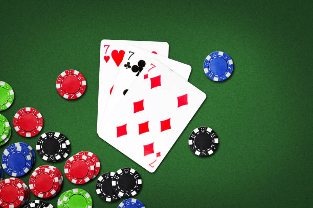 istock Three sevens, and poker chips, on a green background. copy space. gambling. 1409835403