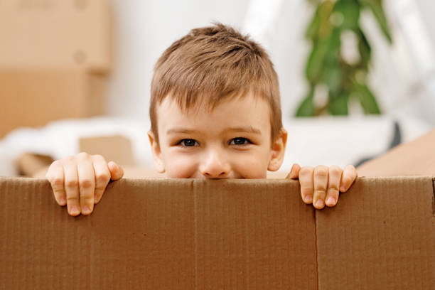 istock Little boy playing inside a moving box on a moving day 1409836838