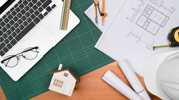 istock Engineer office desk with laptop, blueprints, hard hat and engineering tools. Flat lay, top view. 1409838097